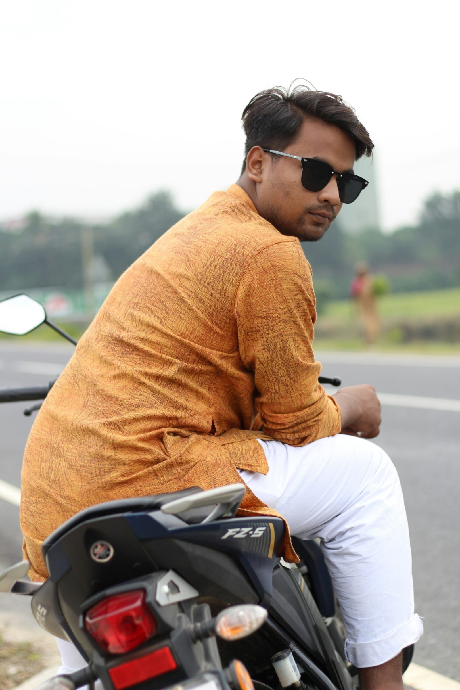 a man riding on the back of a motorcycle down a road