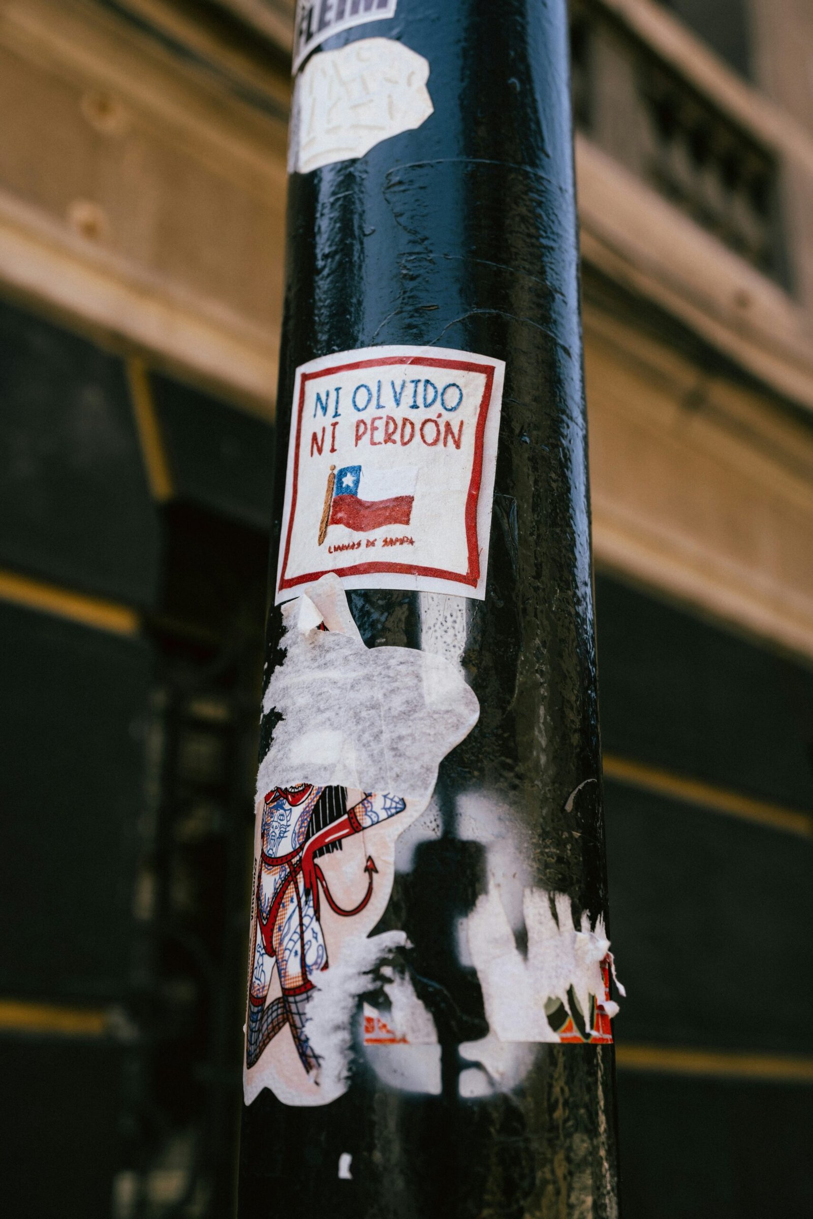 a pole with stickers on it in front of a building